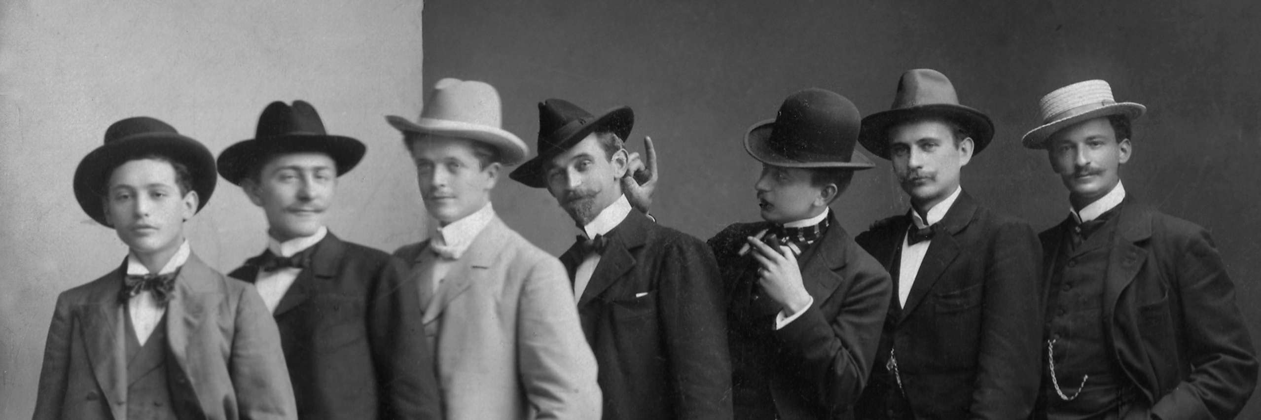 Schwarzweißfotografie – Historische Aufnahme von 7 Männern mit Hüten die herumalbern