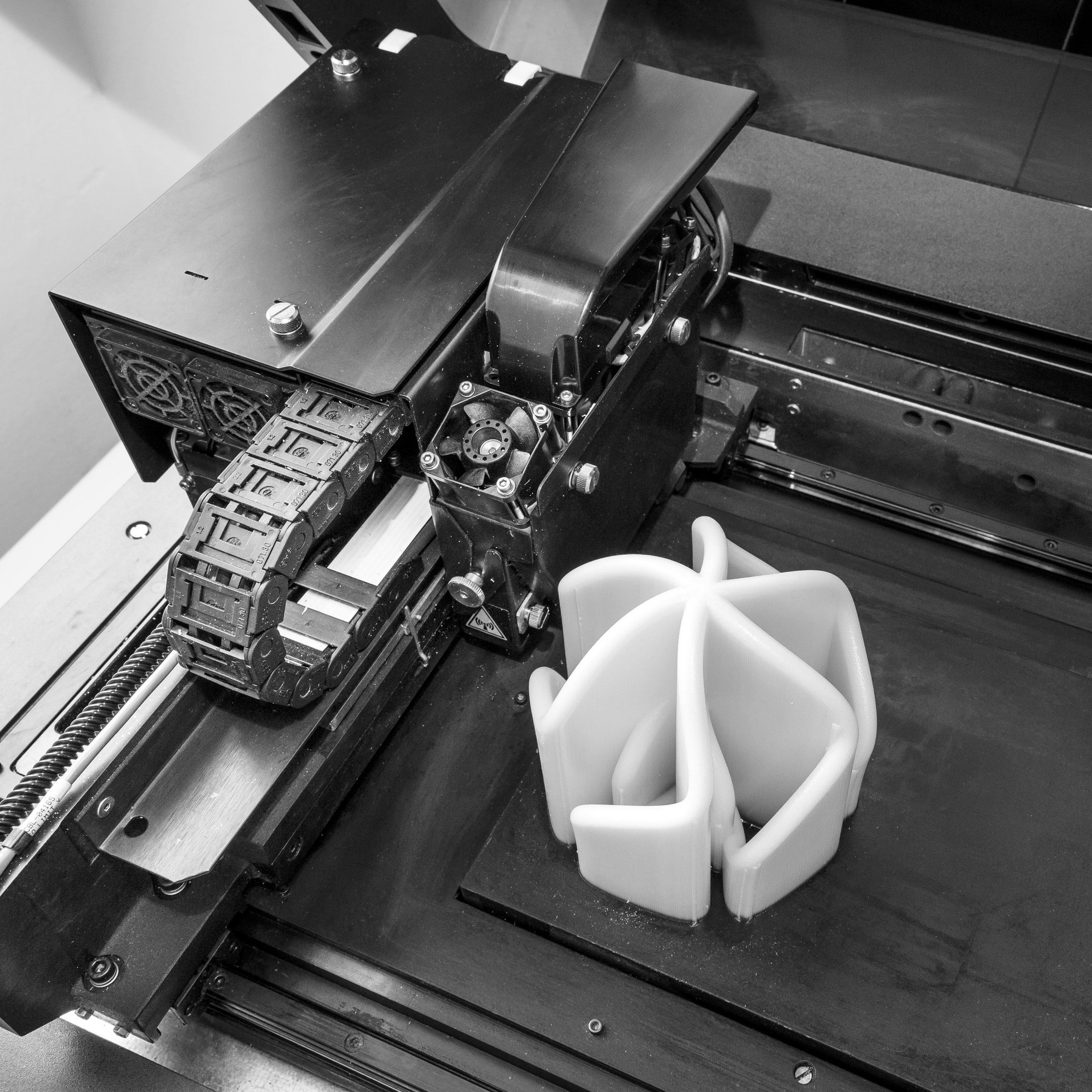 Schwarzweißbild eines Werkstücks, das gerade im 3D Drucker gedruckt wird